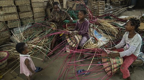 A family weave 'wine carriers' at Nigeria's largest cane 'village' under the bridge in the Maryland District of Lagos.