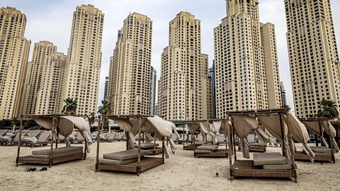 AFP via Getty Images Empty beach chairs with tall hotel buildings in background (Credit: AFP via Getty Images)