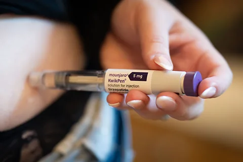 Getty Images A person injecting themselves in the abdomen with a weight-loss drug using a pen injection system (Credit: Getty Images)