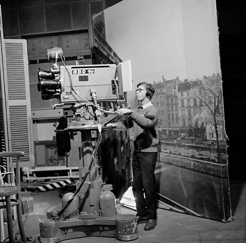 A BBC camera engineer in an early TV studio recording a performance