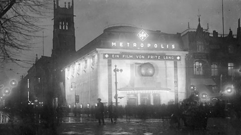 Photo of a 1920s German cinema lit up and screening the film Metropolis