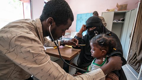 A doctor tends to a child at a primary healthcare clinic in Sudan. 