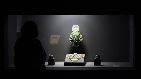 A museum exhibition with a jade mask, jade necklace and bracelets, 