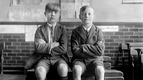 Two schoolboys sitting in a classroom in the 1920s.
