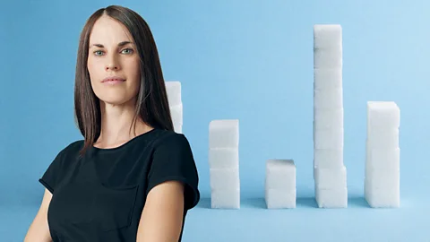 BBC/ Getty Images A portrait of Melissa Hogenboom wearing a black top in front of an image of stacks of sugar cubes with a blue background (Credit: BBC/ Getty Images)