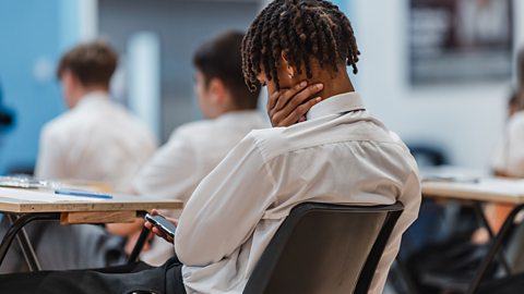 Student using a phone in a classroom.