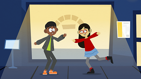 A boy smiles and points at a girl who is also smiling.