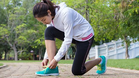 Teenage runner lacing up their trainers.