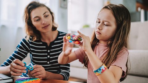 Young girl and her mum playing with fidget toys.