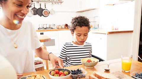 Boy looks at healthy breakfast with disappointment