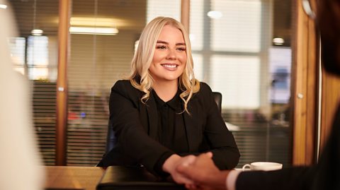 Teen girl at first proper job interview shales hands with interviewer