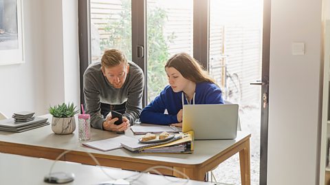 father helps teen girl as she revises