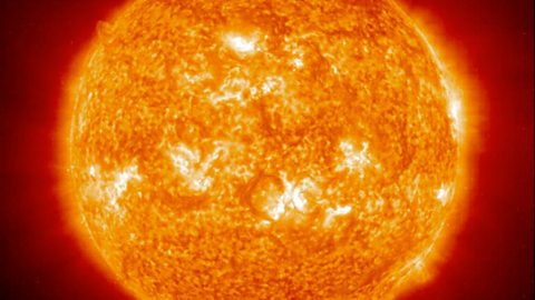 A close-up image of the sun in space. It's a glowing orange sphere, with several lighter yellow and white-ish patches dotted inside it. 