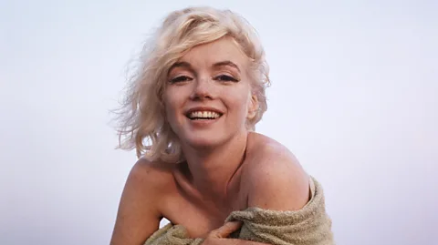 Photo: George Barris © INHOLLYWOODLAND The George Barris Estate Marilyn Monroe with a beach towel around her shoulders, photographed on a beach in Santa Monica, California (Credit: Photo: George Barris © INHOLLYWOODLAND – The George Barris Estate)