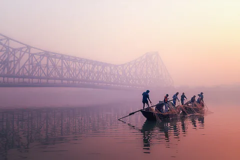 Marco Rutten/ World Food Photography Awards Fishermen pull in nets from a small boat at sunrise on the Hooghly River under Kolkata's Howrah Bridge (Credit: Marco Rutten/World Food Photography Awards)