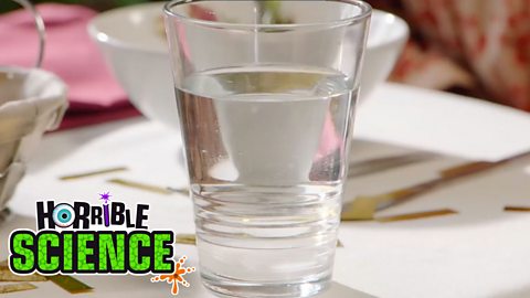 Image of salt being stirred into a glass of water. 