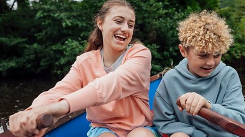 sister and brother rowing a boat