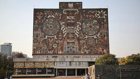 a landscape image shows the front of a university library. It's a striking, ten-storey building entirely covered in a 4,000 square-metre mosaic made from natural stone. 