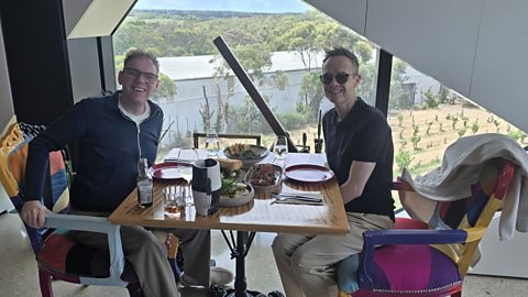 Two men in a restaurant of cafe, smiling to camera.
