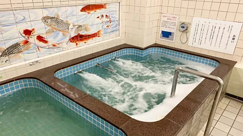 Konparu-yu A Kutani porcelain mural of koi carp sits above one of Konparu-yu's tubs (Credit: Konparu-yu)