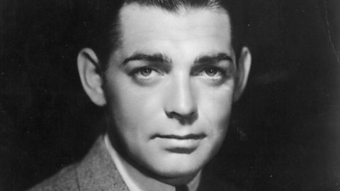 A black and white head shot of actor Clark Gable. He's looking directly into the camera with a faint, closed-lipped smile.