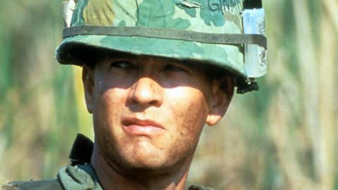 A colour photograph of Tom Hanks in the film Forrest Gump. It's a head and shoulders shot of Forrest in his military uniform during the Vietnam War. He's looking seriously off to the left of the camera.