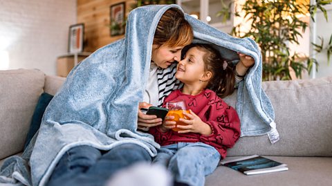 Mum on smart phone but she is paying attention to her child.