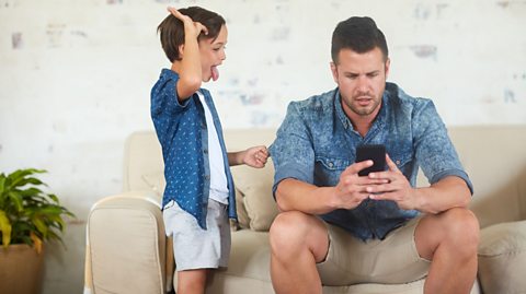 Dad on a phone ignoring his son.
