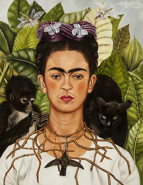 Nickolas Muray/ Collection of Mexican Art Untitled Self-Portrait with Thorn Necklace and Hummingbird (1940) by Frida Kahlo is displayed at an exhibition at Tate Modern (Credit: Nickolas Muray/ Collection of Mexican Art)