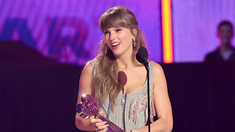 Taylor Swift receiving an award at a ceremony