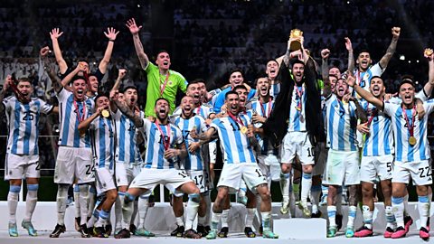 Lionel Messi and the Argentina men's national football team lifting the World Cup trophy in 2022