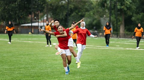 Female soccer players celebrate after winning a match