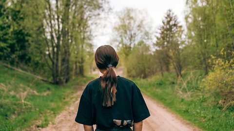 teenage girl enjoys a walk down a country path