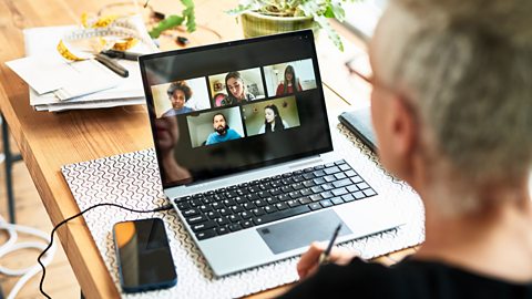 Someone working from home, speaking to colleagues on a video call. 