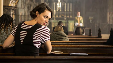 Alamy Phoebe Waller-Bridge looks back at the camera while sitting on a pew in church in Fleabag (Credit: Alamy)