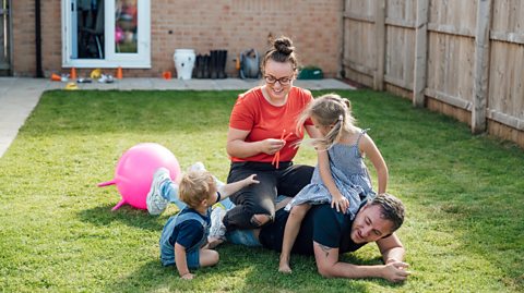 summer family fun - wrestling and playing on a lawn
