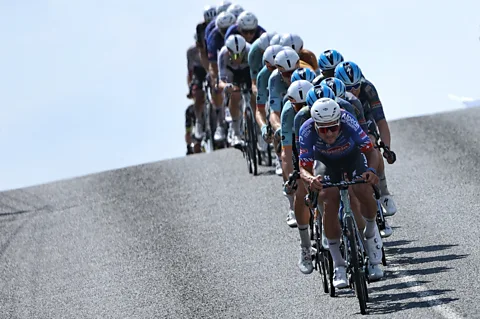 Getty Images A line of Tour de France riders cresting over a hill (Credit: Getty Images)
