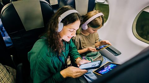mum and daughter use devices own a holiday flight