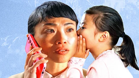 BBC/ Serenity Strull/ Getty Images A young girl whispers a word in a woman's ear while the woman is on the phone (Credit: BBC/ Serenity Strull/ Getty Images)
