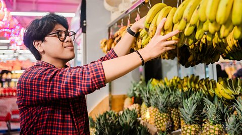 An image of someone buying bananas from a supermarket