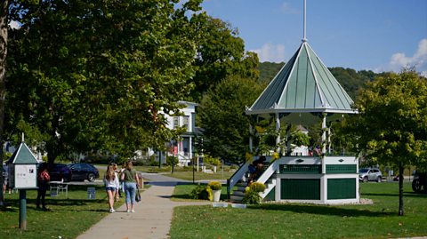 A light green gazebo in the town centre of New Milford, Connecticut, USA, which is surrounded by trees and pathways
