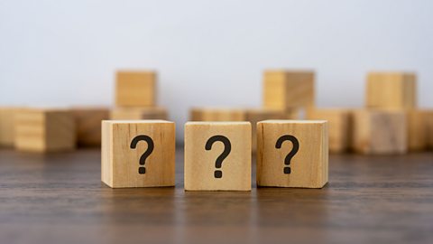 Three wooden blocks with question marks on.