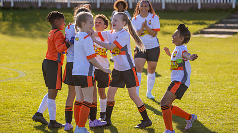A football team of children hugging.