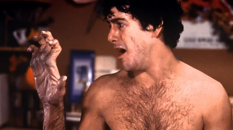 Getty Images David Naughton looks at his hand as he begins to transform into a werewolf in An American Werewolf in London (Credit: Getty Images)
