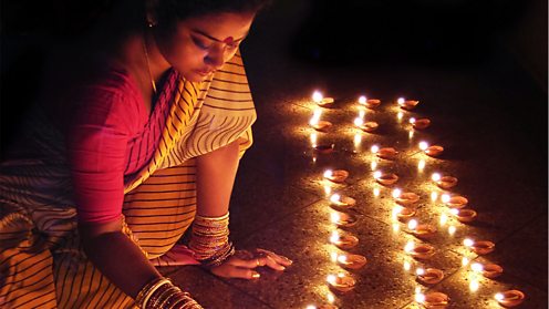 Woman lighting earthen lamps during Diwali