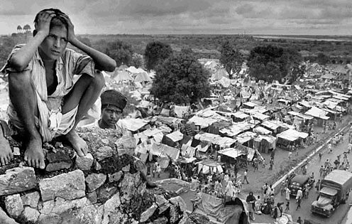 A distraught boy sat near a refugee camp in Delhi during the Partition of India.