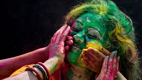 Indian woman covered in coloured powder during a Holi festival in Kolkata, India