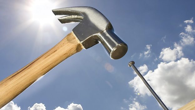 man hitting a nail with a hammer in wood Stock Photo - Alamy