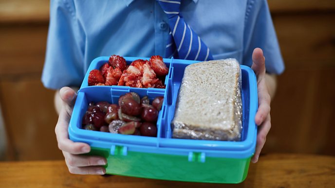 A child holding a healthy packed lunch