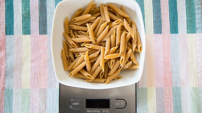 Portion of dried pasta on kitchen scales